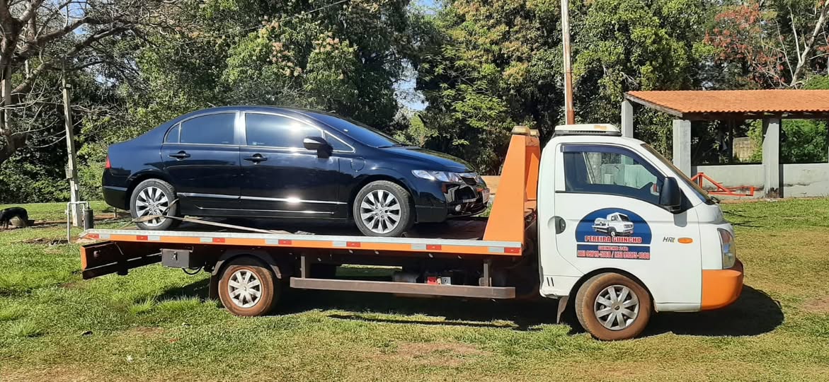 Guincho Pereira transportando sedã preto em área aberta